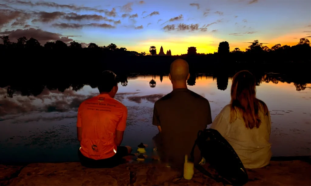 Visit sunrise at Angkor Wat temple with local guide, sitting outer moat of the temple