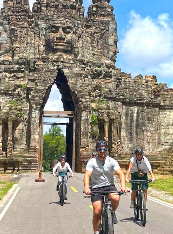 Cycling through the south gate of Angkor Thom with family tour, Bike of the Angkor Temple and History Tour by bike with local Lunch